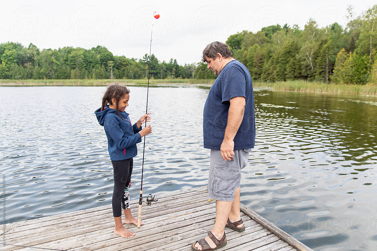 Girl and father fishing together